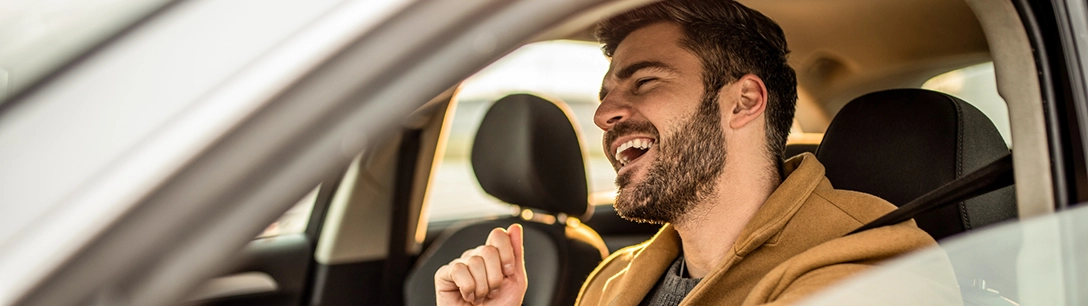 Homme souriant au volant